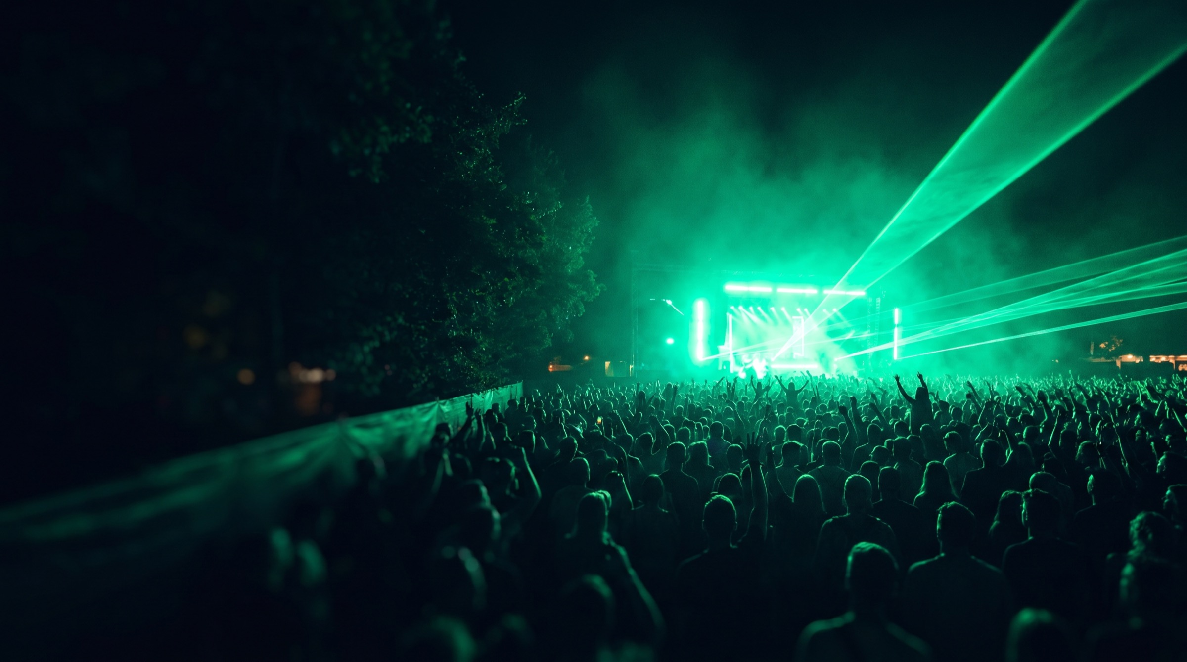 A festival crowd under green stage lights